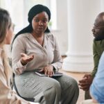 Young female counselor providing advice to a group of consumers